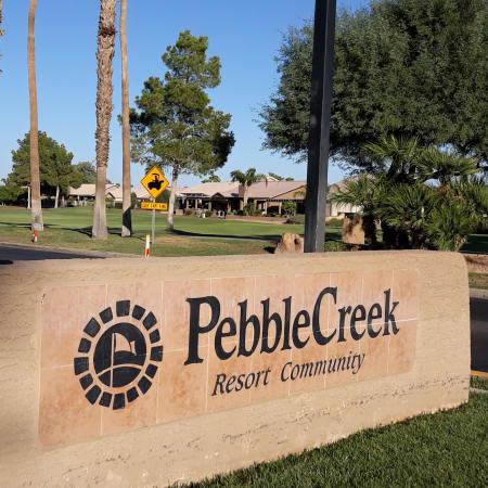 Photo of Pebble Creek Resort Community's entrance sign with golf green and trees